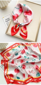Detail of cherry print silk scarf showing satin texture and cherry pattern bow decoration
