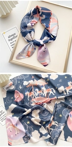 Detail of satin silk scarf with carousel and moon prints in navy blue and pink colors
