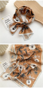 Detail of vintage amber floral silk scarf showing fabric texture and edge stitching