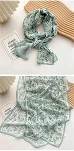 Close-up of lightweight green floral silk scarf with elegant cream-colored borders