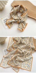 Detail of floral chiffon scarf tied in a bow with yellow flowers and orange borders