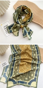 Detail of a lightweight long silk scarf with olive green and ochre geometric patterns
