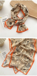 Close-up of lightweight floral silk scarf with elegant orange borders and chiffon texture