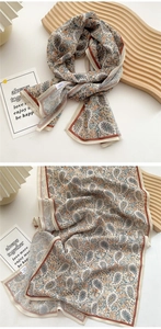 Detail of floral paisley long scarf with burnt orange trim on ivory silk-like fabric