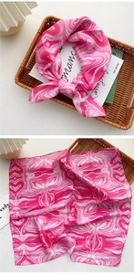 Detail eines rosa Seidenschals mit Marmor-Print, feinen Rollrändern und Glanzeffekt