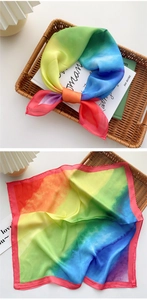 Nahaufnahme eines bunten Seidentuchs mit Regenbogenverlauf an einem Weidenkorb