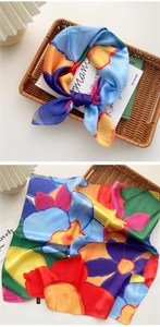 Detailansicht eines farbenfrohen Satin-Seidentuchs mit Blumenmuster und Saumkanten