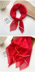 Detail of red thin square scarf showing lightweight semi-transparent fabric texture