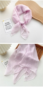 Close-up of lightweight lavender silk scarf with white rolled edges and brand label