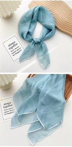 Detail view of light blue striped sheer silk scarf with soft chiffon texture and elegant drape