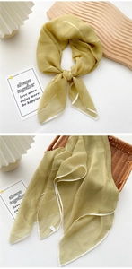 Detail of mustard yellow sheer square scarf with white rolled edges on woven basket
