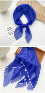 Detail of royal blue chiffon square scarf with white edge stitching and soft texture