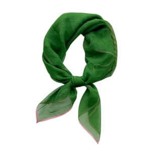 Dark green silk scarf with contrast pink rolled edges in a stylish knotted display