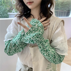 Close-up of floral ice silk sun protection sleeves with green leaf pattern and ruffled cuffs