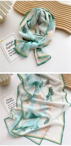 Detail of elegant long silk scarf featuring lotus patterns and semi-transparent texture