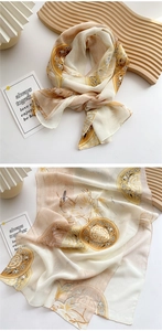 Detail of elegant long silk scarf with traditional floral and bird patterns in apricot