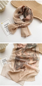 Detail of champagne silk scarf featuring traditional Chinese landscape print and fine texture