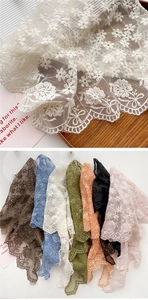 Detail of floral lace scarf collection featuring embroidery and scalloped edges