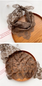 Detail of brown hollow lace scarf with floral embroidery and scalloped edges