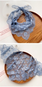 Close-up of light blue lace bandana featuring intricate floral hollow embroidery patterns