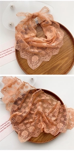 Detailed embroidery on orange-pink lace triangle scarf with elegant scalloped edges