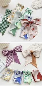 Detail of silk-feel skinny scarves featuring green checkerboard and floral prints for hair