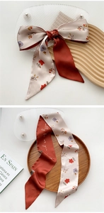 Detail of floral skinny scarf with double-sided cream flower and rust red design