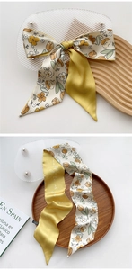 Macro detail of silk scarf with yellow floral tulip pattern and artistic lettering