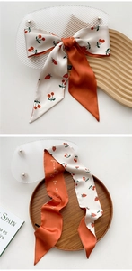Close-up of strawberry and cherry patterns on a double-sided silk-like skinny scarf