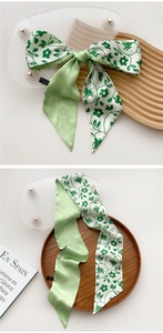 Detail of light green floral silk scarf with elegant handwritten text and smooth texture