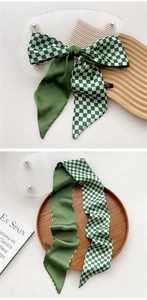 Detail of green and white checkerboard silk scarf used as a stylish bow hair accessory