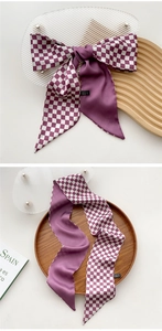 Detailed view of dark purple checkerboard silk scarf tied in a bow and laid flat