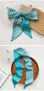 Detail of blue and white checkered skinny silk scarf used as a hair tie or neck wrap