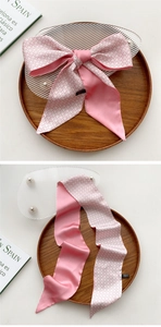 Pink silk-like long scarf with stars pattern used as a bow decoration for outfits