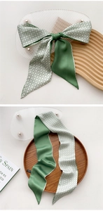 Detail of green silk twilly scarf with geometric star patterns and satin finish