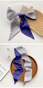 Close-up of narrow silk twilly scarf showing navy blue satin and star pattern texture