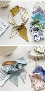 Close-up of assorted floral and polka dot silk twilly scarves with satin finish