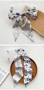 Close-up of elegant blue floral pattern on white silk scarf with pointed end detail