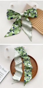 Detail of green floral twilly scarf with as you wish text and botanical pattern