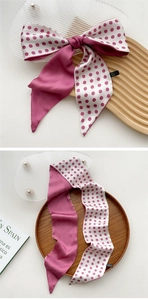 Close-up of silk scarf with red polka dots and solid burgundy double-sided design