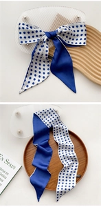 Blue and white polka dot satin hair scarf tied in a bow and hanging naturally