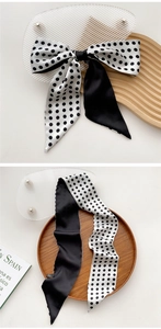 Close-up of elegant black and white polka dot silk twilly scarf with satin finish