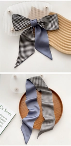 Detail of lilac silk scarf and black white checkered pattern tied in a bow