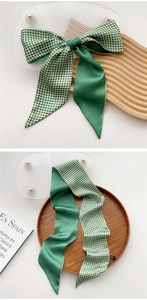 Detail of green checkerboard satin ribbon scarf showing fabric texture and bow style