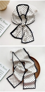 Close-up of French vintage polka dot silk scarf tied on a stylish white pleated lamp
