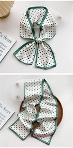 Close-up of silk scarf with dark green polka dots and matching green borders