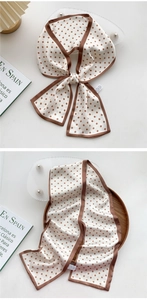 Detailed view of cream silk twilly scarf with brown polka dots used as a hair accessory