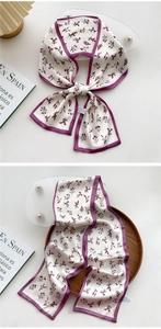 Detailed view of cream floral skinny scarf tied as a bow with deep purple borders