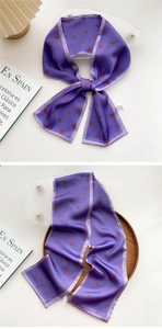 Close-up of a long purple silk scarf with small floral prints and lilac edge stitching
