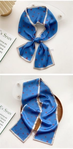 Detail of silk-feel long scarf in royal blue with red floral print and gold edges